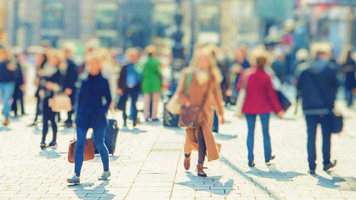 A blurred photo of a crowded town centre street.