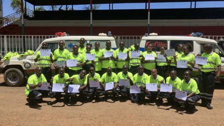 Graduates from the initial ambulance training programme holding their certificates.