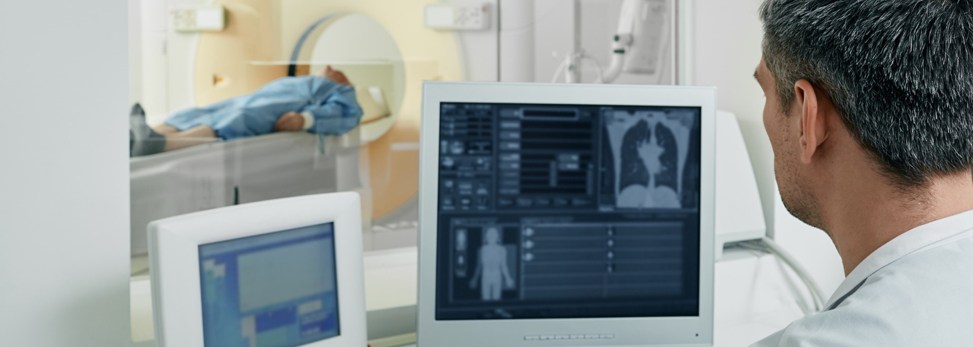 A medical professional observing a CT scan of a patient.