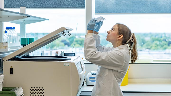 A postgraduate researcher looking at a plate.