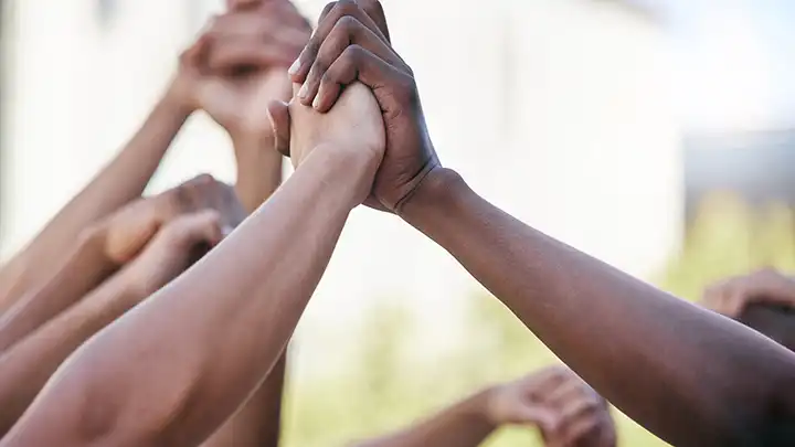 People holding hands raised in the air.
