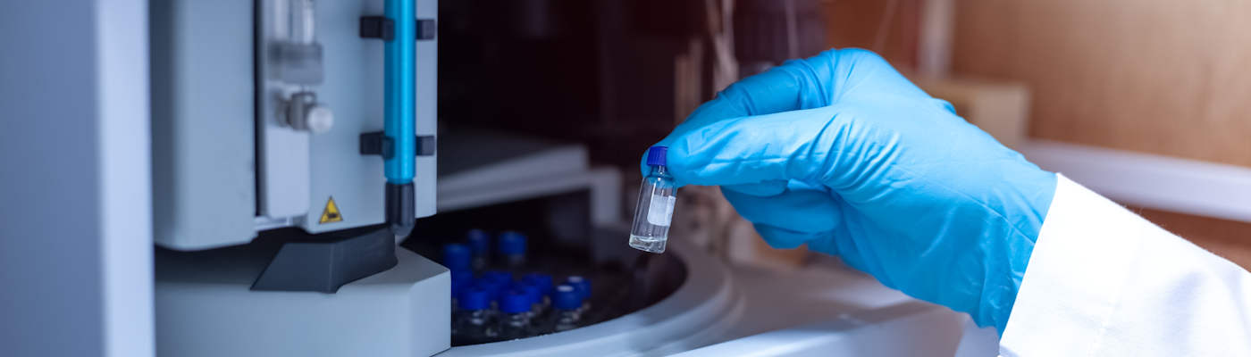 A scientist handling a vial for mass spectrometry.