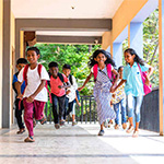 South Asian children running at school.