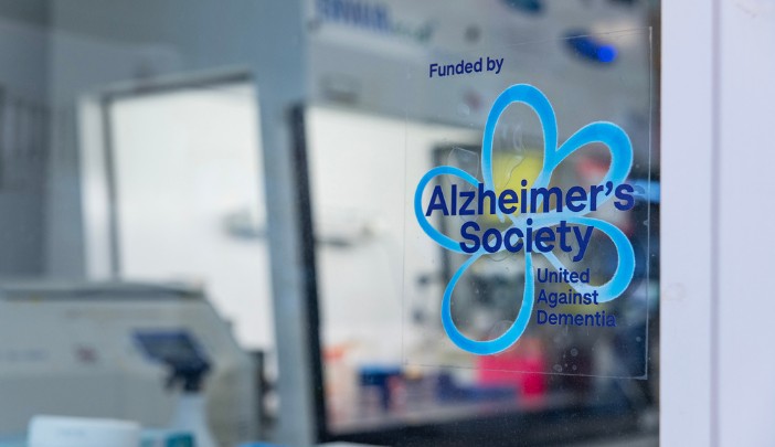 The Alzheimer's Society logo sticker on a window in a lab