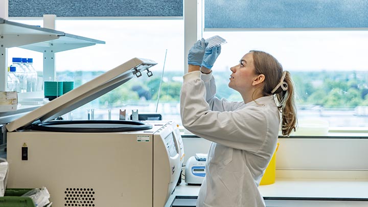 Poppy, a postgraduate researchers, examining a 96 well plate.