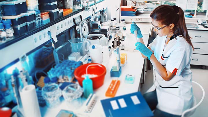 A researcher using a pipette in a lab.